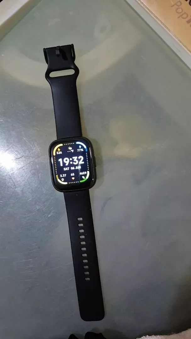 Orologio nero acceso con cinturino disteso sul tavolo